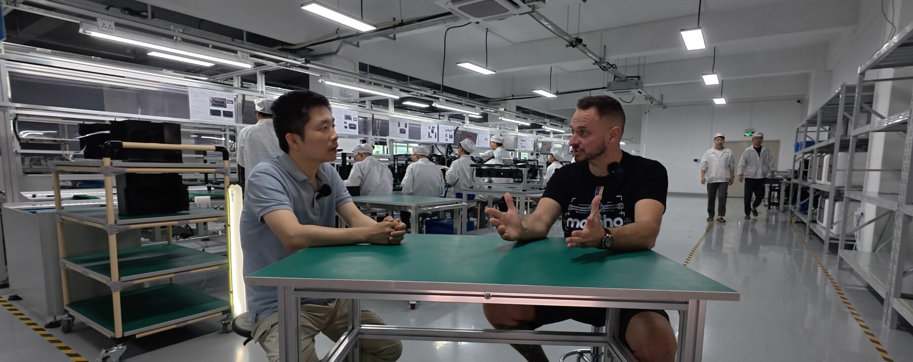 Sam Prentice talking with a colleague on a factory floor